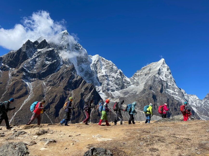 Trekking group against towering Himalayan peaks.